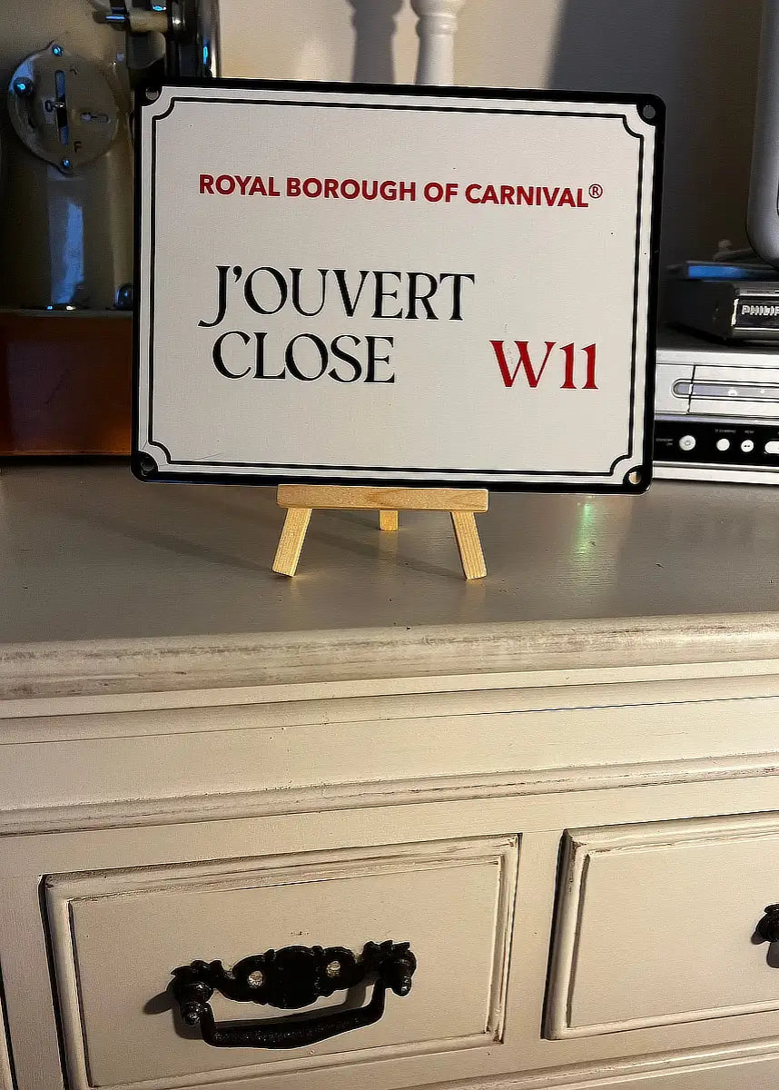 J'Ouvert Close W11 decorative carnival street sign displayed on a wooden mini easel atop a vintage white chest of drawers