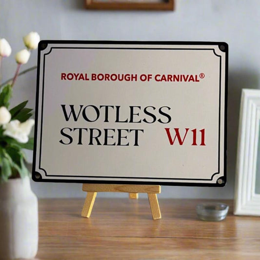 Mini street sign Wotless Street Sign -on an easel with a vase of flowers at the side