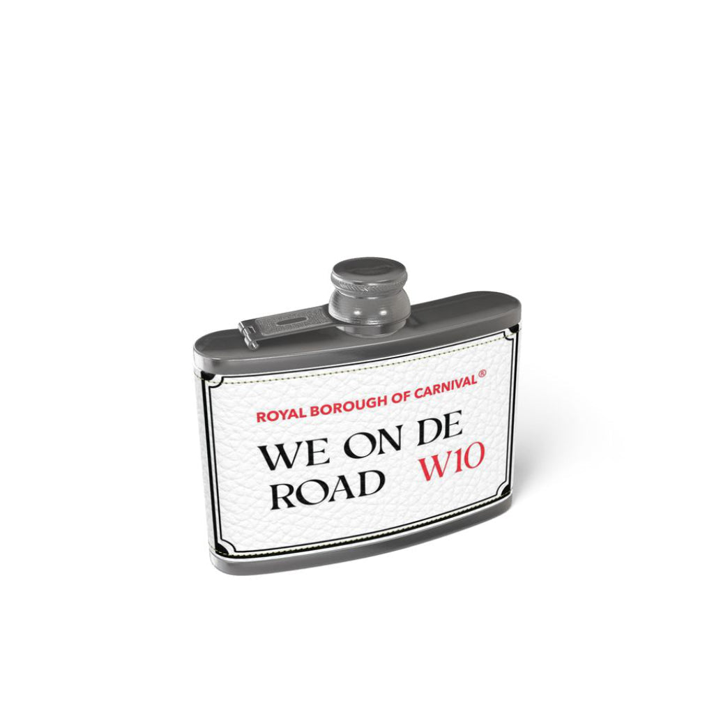 A white Nappa Leather hip flask with black text on the front that reads “We On De Road.” The back of the flask is plain with no design or text.