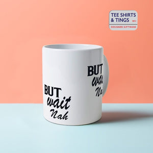 But Wait Nah white mug with black font displayed against a split coloured orange and blue surface.