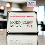 Moko Jumbie Mini Metal street sign on a reflective work surface