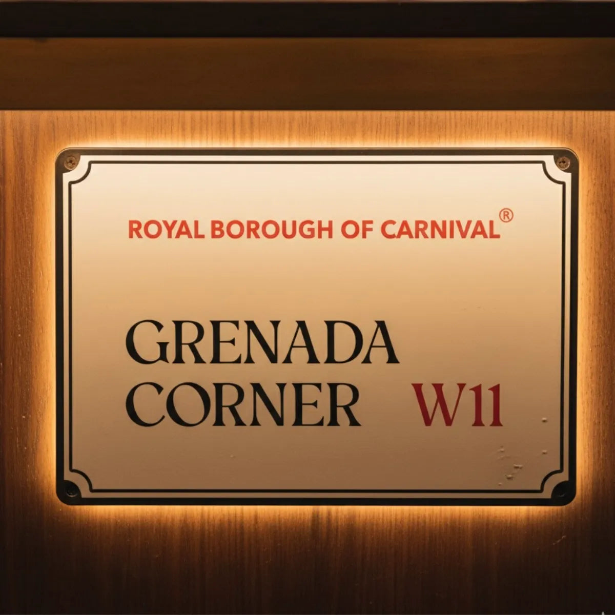 Grenada Corner W11 decorative street sign mounted on rich wood panelling with warm ambient backlighting