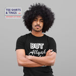 Man with a huge Afro wearing a black organic cotton teeshirt with his arms folded across his chest looking vex. The teeshirt reads But Allyah Mecking Joke. 100% organic cotton