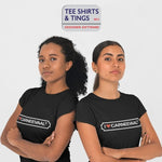 Two women standing back to back wearing 100% black organic tee shirt featuring I ❤️ CARNEEVAAL®️