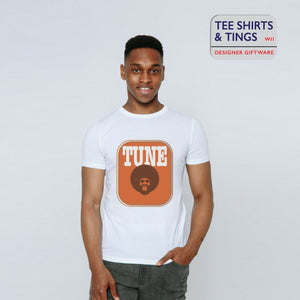 A guy in the studio wearing a white teeshirt with an amber rectangle on the front with an image of a man with afro hair and the wording in white saying TUNE. 100% organic cotton